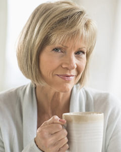 Woman considering something over a cup of drink