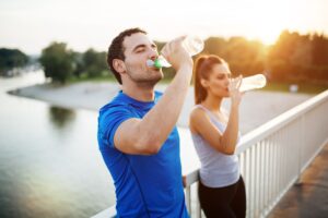 Two runners drinking water