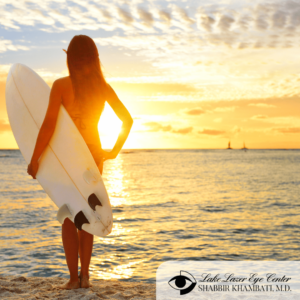 Woman holding surfboard looking at ocean 
