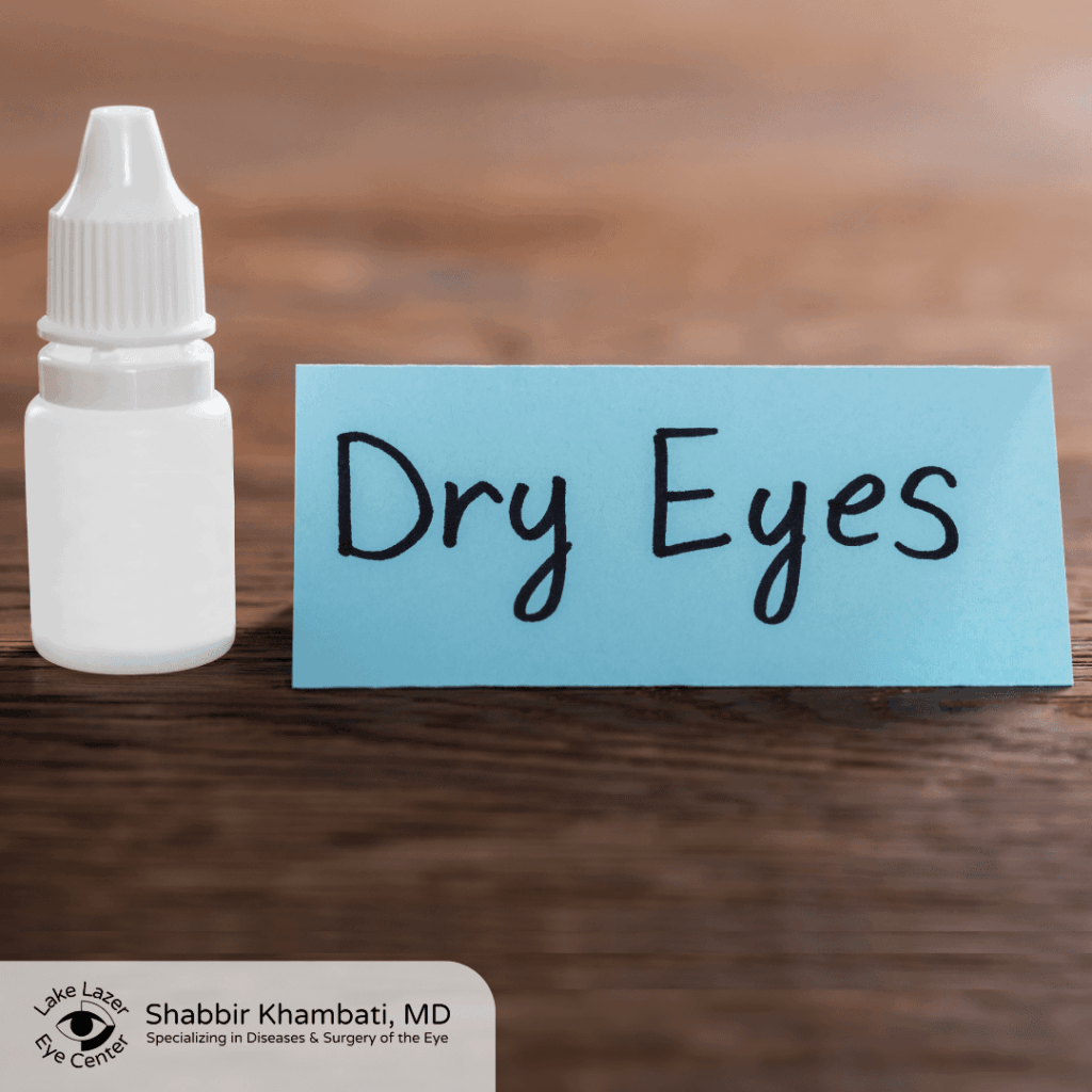 A small bottle of eye drops next to a blue card labeled "Dry Eyes" on a wooden surface.
