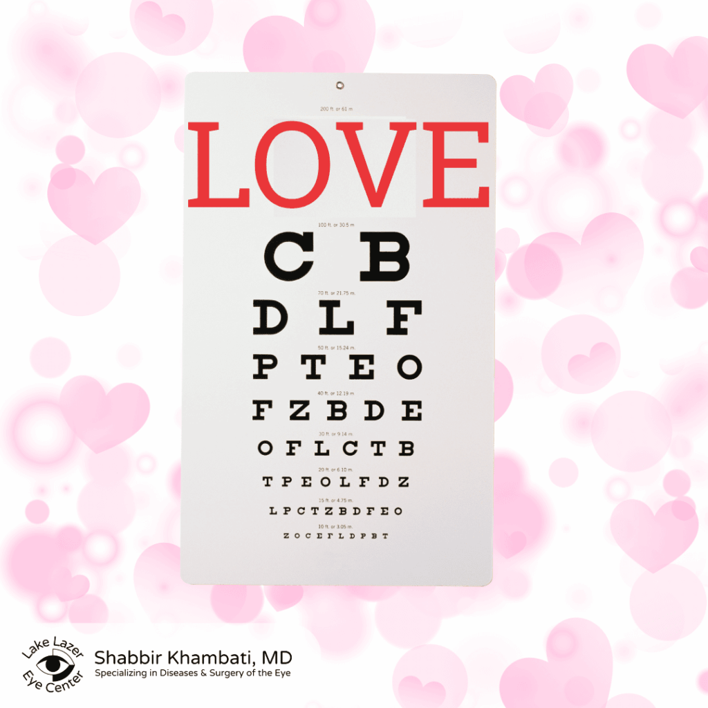 Eye chart styled like a Snellen vision test with the word “LOVE” in large red letters at the top, smaller black letters below, set against a pink background with heart graphics and the Shabbir Khambati, MD eye center logo in the corner.